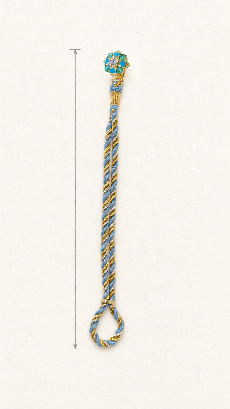 A braided rakhi bracelet with a floral motif and a loop at the bottom, shown on a plain light background with a vertical measurement marker along the left side.