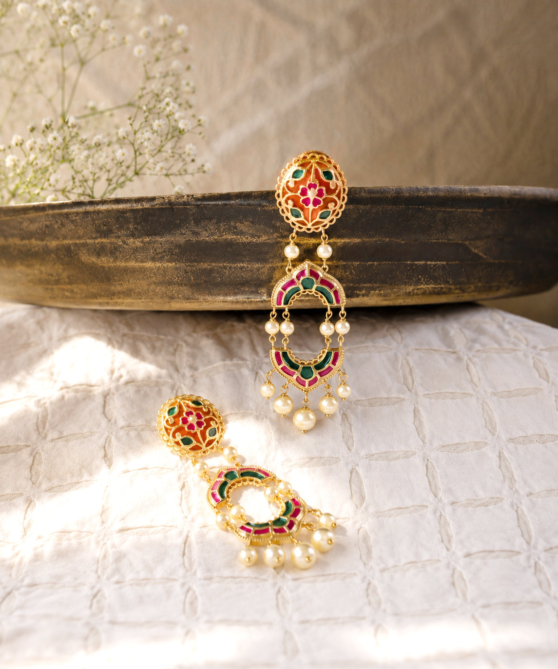 A pair of 925 silver traditional Indian dangle earrings with colorful enamel work in pink, green, and orange, adorned with small white pearl beads.