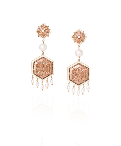 A pair of rose gold and white pearl dangle 925 silver earrings with hexagonal and floral motifs.